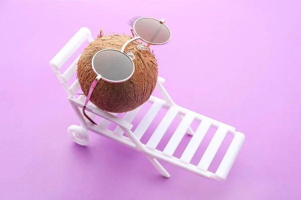 Funny Coconut med solglasögon och solbädd på färg bakgrund — Stockfoto