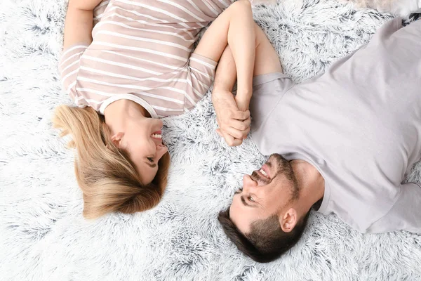 Pareja feliz enamorada acostada en la cama, vista superior —  Fotos de Stock