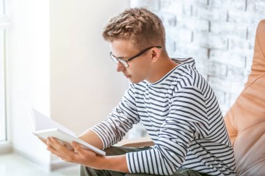 Sınava hazırlanırken erkek öğrenci okuma kitabı