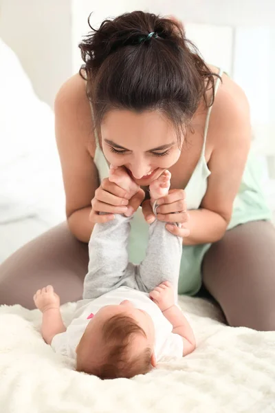 Happy mother with cute little baby on bed at home — Stock Photo, Image