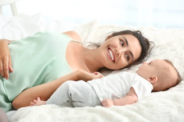 Boldog anya aranyos kis baba feküdt az ágyban — Stock Fotó