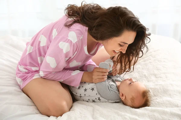 Boldog anya aranyos kis bébi ágyon otthon — Stock Fotó