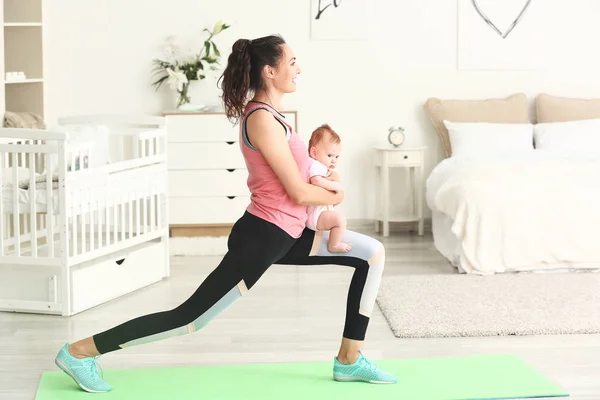 Madre practicando yoga con un lindo bebé en casa —  Fotos de Stock