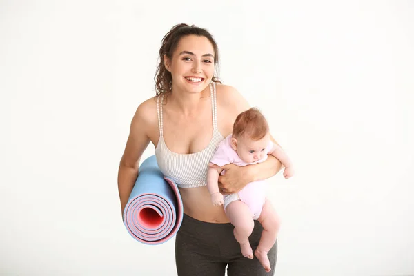 母亲与瑜伽垫和可爱的小宝宝在白色背景 — 图库照片
