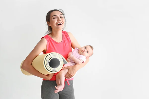 Matka z jogi mat i cute little baby na białym tle — Zdjęcie stockowe
