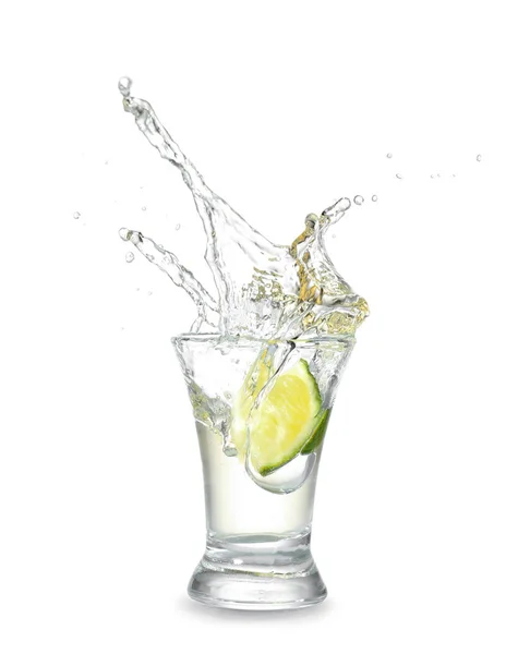 Upuszczenie wapna do szklanki z smaczną Tequila na jasnym tle — Zdjęcie stockowe
