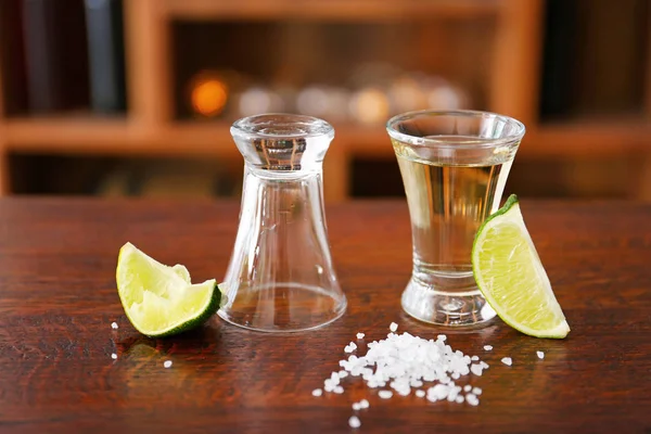 Tomas de tequila sabroso con lima y sal en la mesa en el bar —  Fotos de Stock