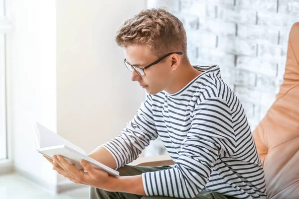 Male student reading book while preparing for exam — Stock Photo, Image