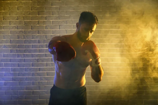 stock image Strong male boxer against brick wall