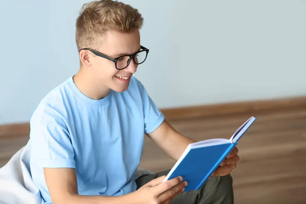 Estudiante masculino leyendo libro mientras se prepara para el examen en interiores —  Fotos de Stock