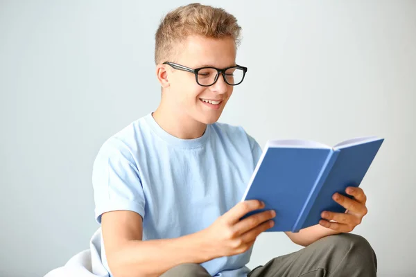 Чоловік читає книгу під час підготовки до іспиту на світлому фоні — стокове фото