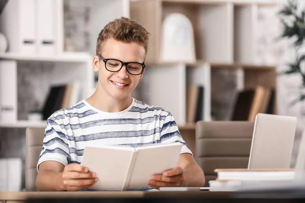 Estudiante masculino leyendo libro mientras se prepara para el examen —  Fotos de Stock