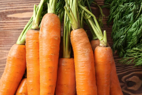 Tasty fresh carrot on wooden background, closeup — Stock Photo, Image