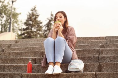 Güzel genç kadın lezzetli burger açık yemek