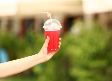 Plastik fincan açık havada lezzetli kokteyl ile genç kadın