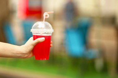 Plastik fincan açık havada lezzetli kokteyl ile genç kadın