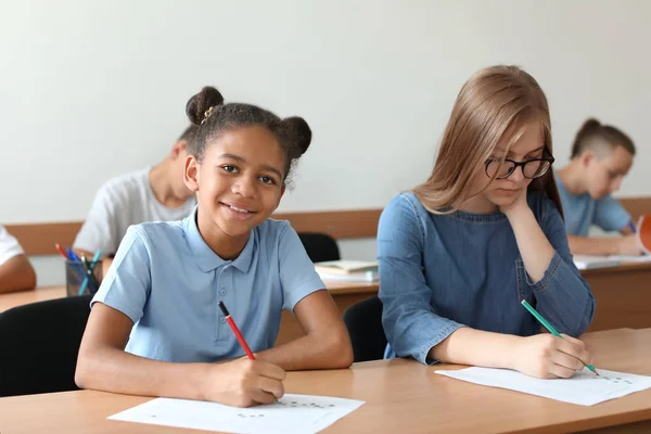 Teenage girls passing school test in classroom — Stock Photo, Image