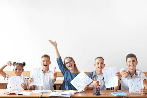 Colegas felizes com resultados de teste escolar em sala de aula — Fotografia de Stock