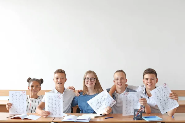 Colegas felizes com resultados de teste escolar em sala de aula — Fotografia de Stock