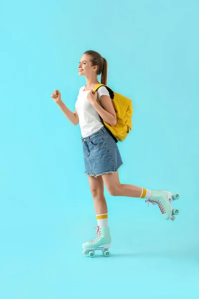 Beautiful young girl on roller skates against color background — Stock Photo, Image