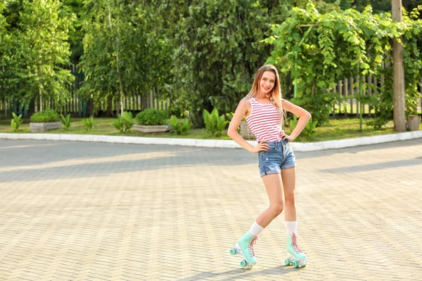 Beautiful young woman on roller skates outdoors — Stock Photo, Image