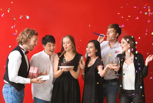 Grupo de amigos comemorando aniversário em fundo de cor — Fotografia de Stock