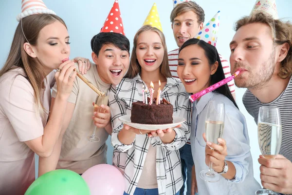 Grupo de amigos comemorando aniversário em fundo claro — Fotografia de Stock