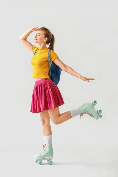 Menina bonita em patins contra fundo leve — Fotografia de Stock
