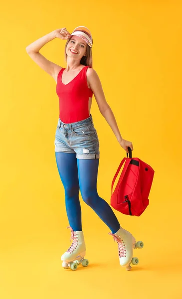 Hermosa mujer joven en patines sobre fondo de color — Foto de Stock