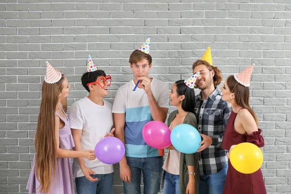 Group of friends with Birthday decor near brick wall — Stock Photo, Image