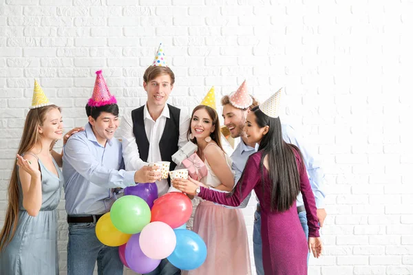 Grupo de amigos celebrando cumpleaños en cerca de la pared de ladrillo —  Fotos de Stock