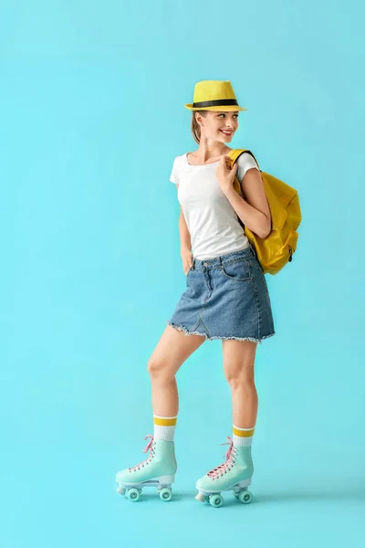 Krásná mladá dívka na kolečkových brusle proti barevnému pozadí — Stock fotografie