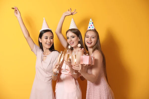 Glückliche Frauen feiern Geburtstag auf farbigem Hintergrund — Stockfoto