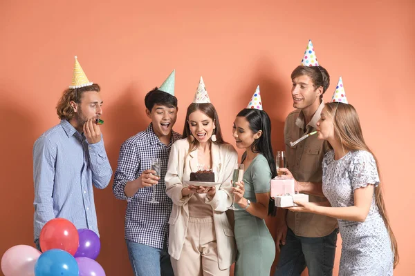 Група друзів, які святкують День народження на кольоровому фоні — стокове фото