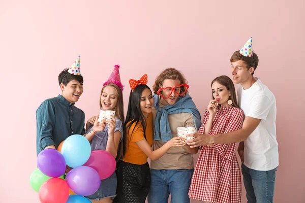 Gruppe von Freunden feiert Geburtstag auf farbigem Hintergrund — Stockfoto