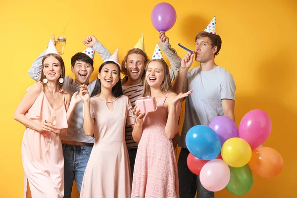 Gruppe von Freunden feiert Geburtstag auf farbigem Hintergrund — Stockfoto