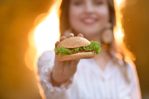 맛있는 햄버거 야외, 클로즈업과 아름다운 젊은 여자 — 스톡 사진