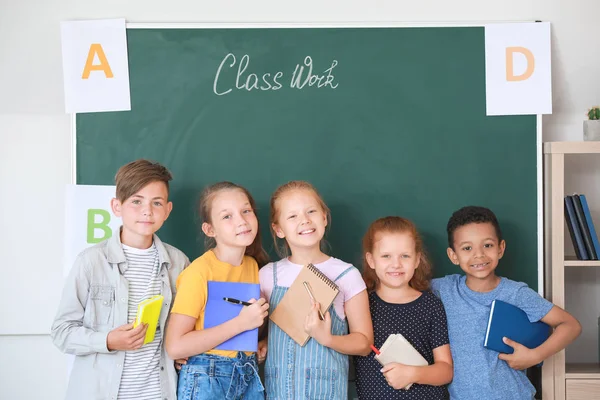 Schattige kleine leerlingen in de buurt van Blackboard in classroom — Stockfoto