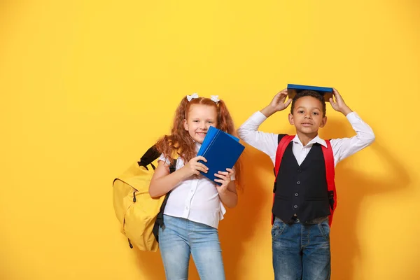 Carino piccoli alunni su sfondo di colore — Foto Stock