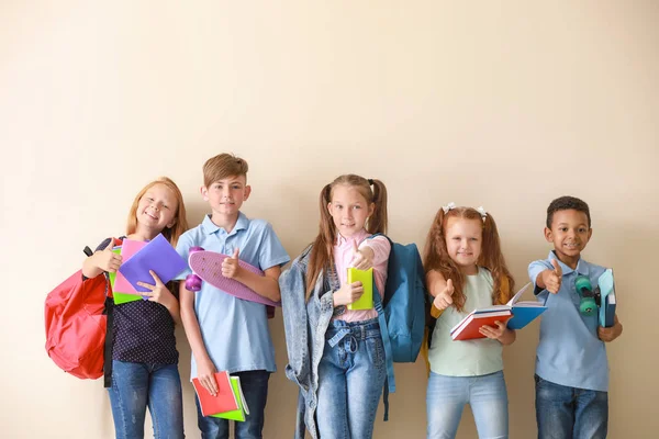 Schattige kleine leerlingen tonen duim-up op lichte achtergrond — Stockfoto