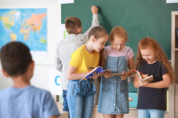 Cute little pupils near blackboard in classroom — Stock Photo, Image