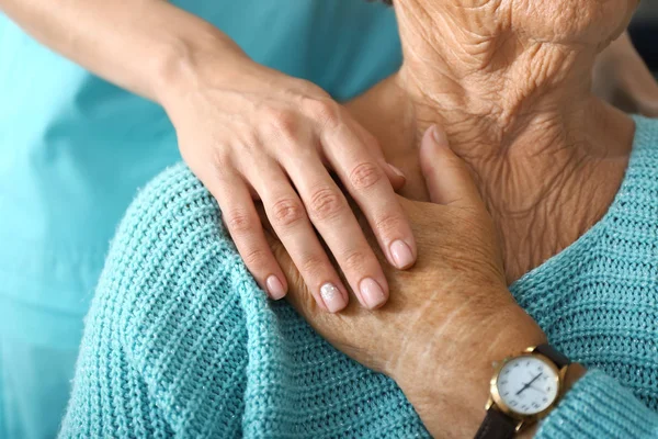 Doctor supporting elderly woman in clinic, closeup — Stock Photo, Image