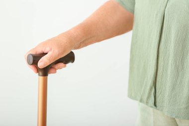 Beyaz arka planda baston lu yaşlı kadın, yakın çekim