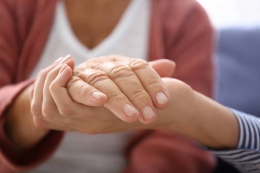 Evde yaşlı anneye destek olan genç kız, yakın çekim