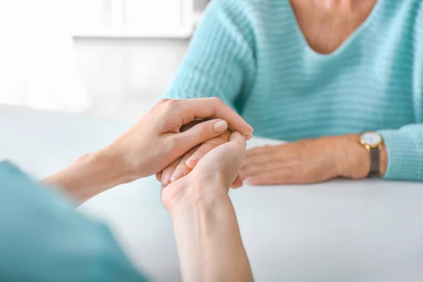 Doctor supporting elderly woman in clinic, closeup — Stock Photo, Image