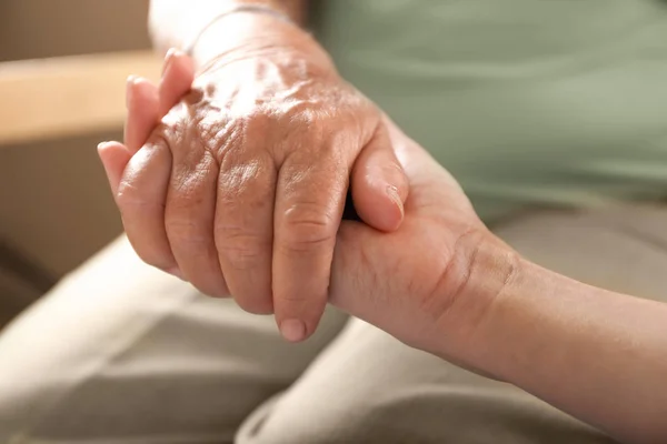 Hija joven apoyando a la madre anciana en casa, primer plano —  Fotos de Stock