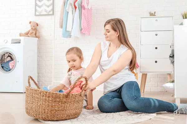 Woman and her little daughter doing laundry at home — Stock Photo, Image
