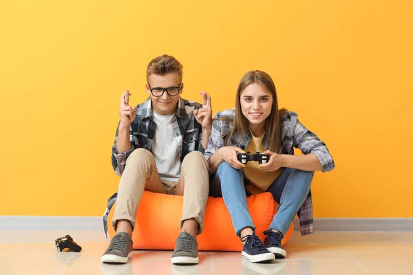 Adolescentes jogando videogame perto da parede de cores — Fotografia de Stock
