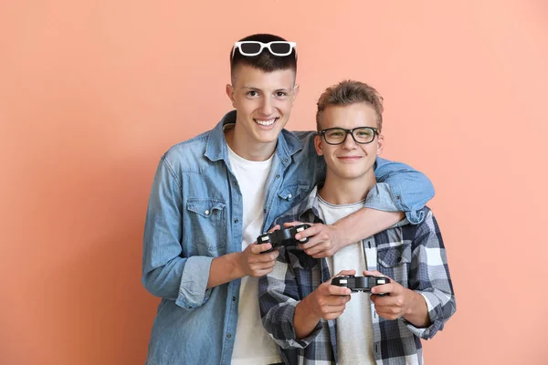 Adolescenti che giocano al videogioco su sfondo a colori — Foto Stock