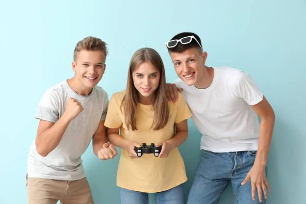 Teenagers playing video game on color background — Stock Photo, Image